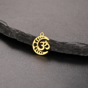 Golden moon phase yoga Om pendant with intricate cutout patterns on a dark stone