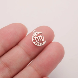 Detailed macro view of a silver Virgo zodiac moon charm held to show its mini size