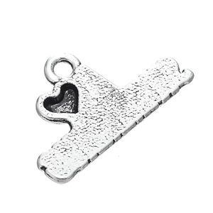 Macro shot of antique silver alloy charm with heart cutout and hammered texture surface