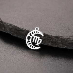 Detailed view of silver stainless steel Virgo zodiac moon phase pendant on dark rock