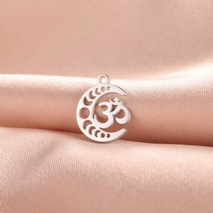Silver stainless steel moon goddess pendant with Om symbol on soft orange silk background