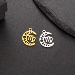 Macro detail of Virgo zodiac crescent moon pendants in gold and silver over black rock