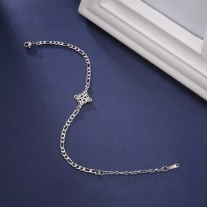 Detailed macro of silver stainless steel Figaro chain with a Celtic witch knot pendant