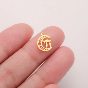 Close-up of golden moon pendant with Chai symbol shown on a fingertip for scale
