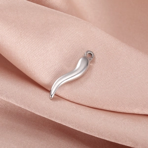Detailed close-up of a polished silver stainless steel chili pendant on pink silk