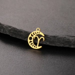 Macro detail of Aries zodiac sign engraved on a 18K gold plated moon pendant