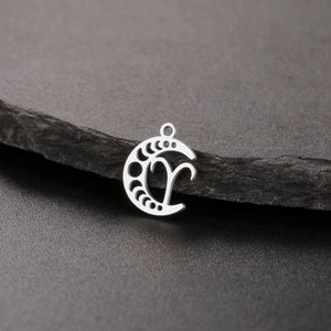 Macro shot of stainless steel crescent moon pendant with Aries constellation pattern