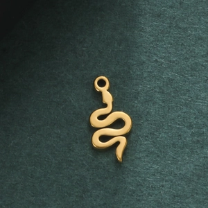 Vue macro d'un pendentif serpent doré poli avec anneau intégré pour bijoux personnalisés