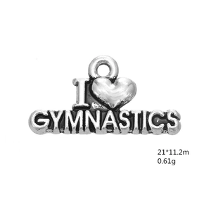 Close-up of antique silver gymnastics heart charm with detailed engraving and hanging loop