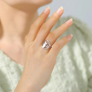 Detailansicht eines ausgeschnittenen Eichhörnchen-Rings aus poliertem Edelstahl am Finger