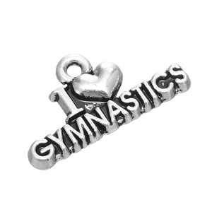 Detail of antique silver gymnastics heart pendant with embossed letters and metal texture