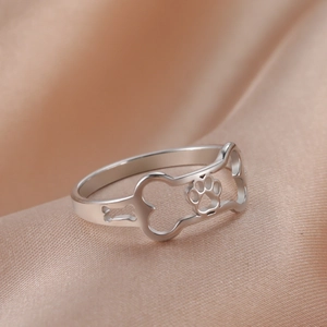 Polished stainless steel ring with hollow dog bone and paw print cutout design