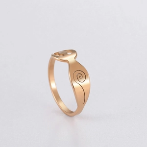 Détail d'une bague en or rose avec silhouette féminine abstraite et texture spirale