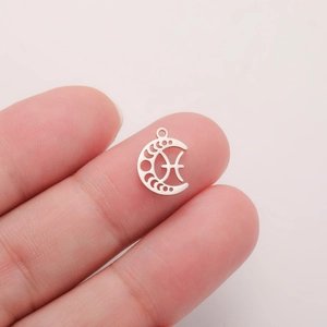 Macro shot of a silver crescent moon Pisces zodiac pendant for DIY jewelry making