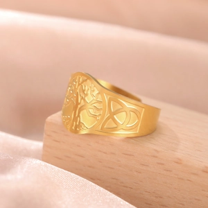 Detailed close-up of golden Tree of Life and Celtic Knot engravings on stainless steel ring