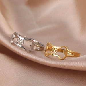Macro detail of gold and silver steel dog bone rings on elegant satin fabric