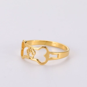 Detailed view of gold-plated ring featuring hollow dog bone and paw print patterns
