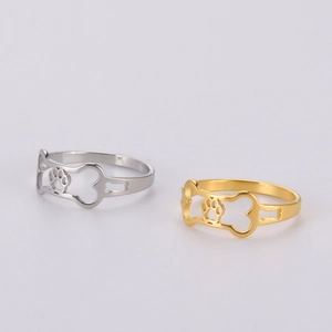 Detail of cutout dog bone and paw print patterns on gold and silver stainless steel rings