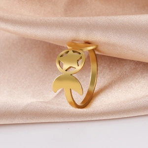 Detailed view of golden stainless steel star and crescent moon ring on silk fabric