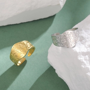 Detailed comparison of gold and silver tree of life rings on white stone textures