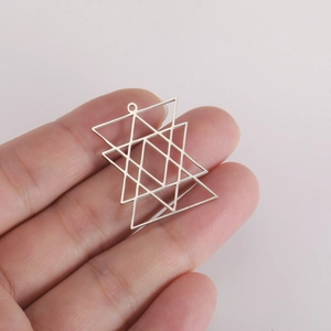 Macro shot of silver Merkaba geometric hollow steel pendant held in hand for detail