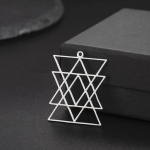 Polished silver geometric star pendant made of overlapping triangles on a gift box