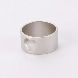 Detailed view of wide silver polished band featuring a centered hollow heart cutout design