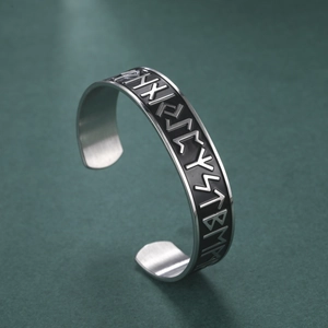 Macro detail of Viking Rune Elder Futhark relief on vintage stainless steel cuff bracelet