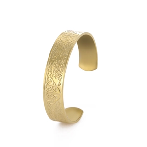 Detail of vintage gold Viking Celtic knot relief carvings on a stainless steel cuff bracelet