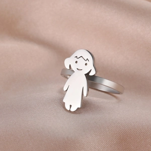 Polished stainless steel girl charm ring on a premium pink silk fabric background