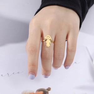 Polished gold stainless steel ring featuring a minimalist cartoon girl motif on finger