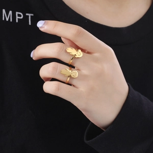 Detailed view of polished gold stainless steel rings with boy and girl character charms