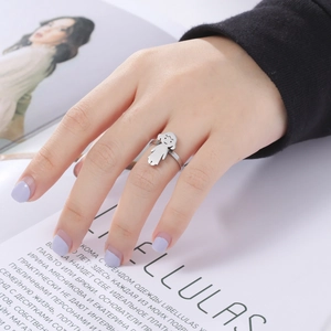 Detail shot of a minimalist silver stainless steel ring featuring a cartoon girl motif