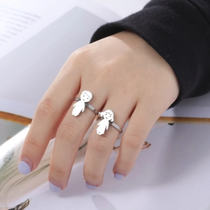 Detail of silver stainless steel rings featuring cartoon boy and girl charms on hand