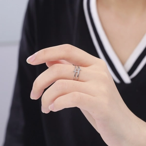 Close-up of high-polished silver crossover ring with a minimalist double-layered design