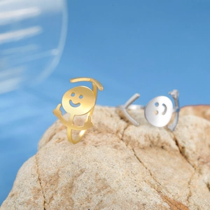 Funny hip hop middle finger rings in gold and silver steel on natural stone background