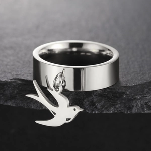 Detalle de anillo ancho de acero inoxidable pulido con colgante de pájaro golondrina