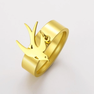 Detalle del anillo mate chapado en oro con un colgante de golondrina colgante moderno