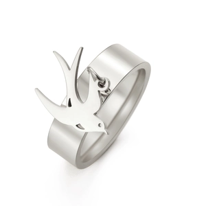 Detalle de un anillo ancho de acero vintage con un colgante de golondrina único colgado