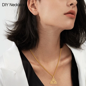 Détail du pendentif céleste doré avec motifs soleil et lune sur une chaîne délicate