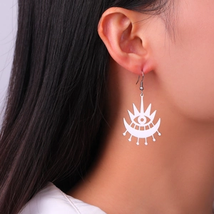 Detailed view of gothic hollow eye pendant earring with crescent moon on a model