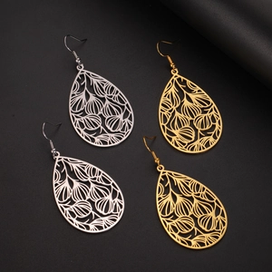 Détail de boucles d'oreilles feuilles évidées en or et argent aux motifs floraux ciselés