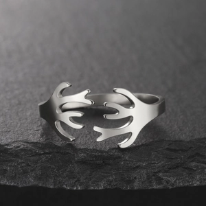 Anello aperto minimalista in corallo argento esposto su sfondo in pietra scura