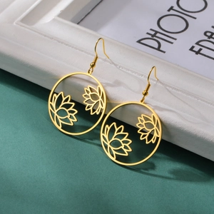 Golden stainless steel hollow lotus flower earrings displayed on a white vintage frame