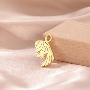 Macro shot of 18K gold plated stainless steel fish pendant charm on pink satin
