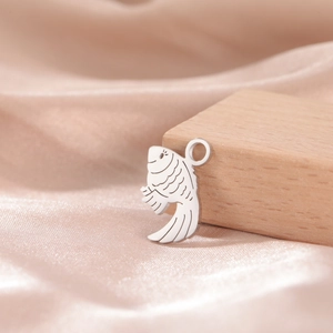 Detailed close-up of a silver clownfish pendant with scales on champagne silk