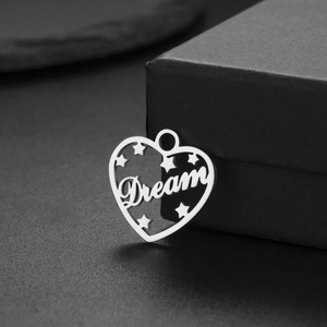 Polished heart-shaped stainless steel pendant featuring a 'Dream' cutout and star patterns