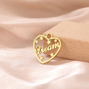 Macro shot of gold-plated hollow heart pendant with Dream letters and star charms