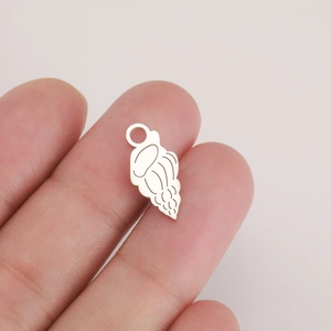Close-up of a tiny silver stainless steel conch pendant held between fingers for DIY jewelry