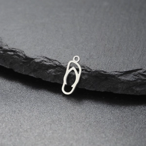 Mini-Edelstahl-Flip-Flop-Anhänger mit Cut-out-Design auf einem Natursteinsockel